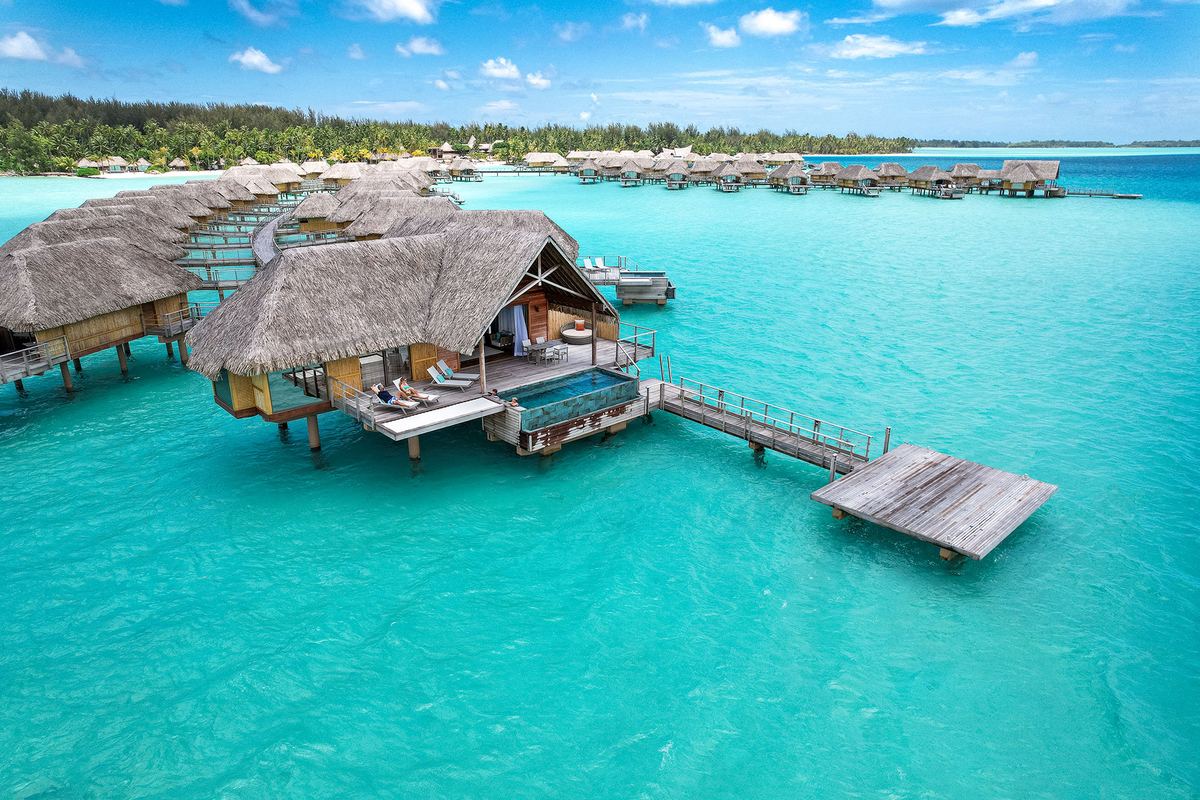 Bungalow su palafitte con il loro pontile, sospesi sopra la laguna turchese di Bora Bora.