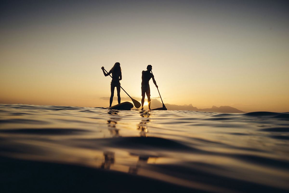 In stand up paddle al tramonto, sulla costa di Tahiti